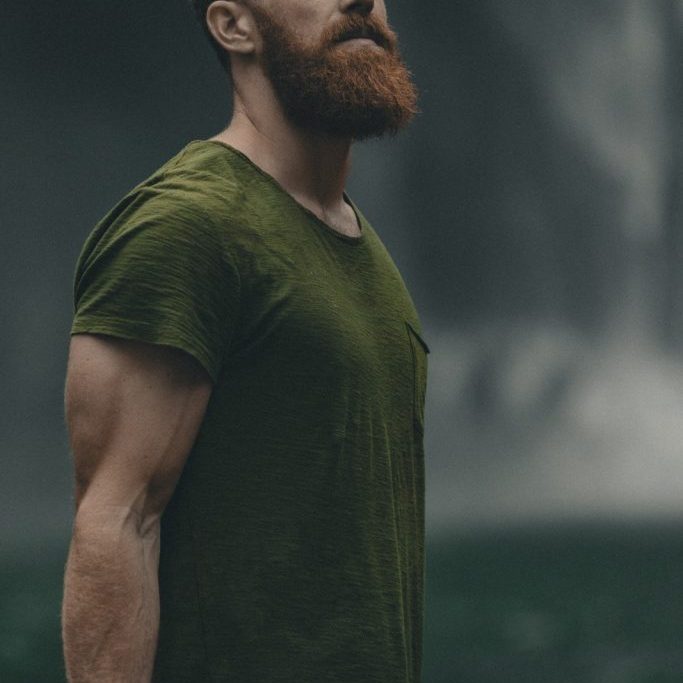 man wearing green crew-neck t-shirt looking upwards